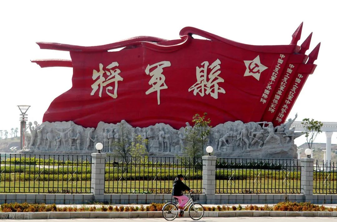 红安将军县标志性雕塑,红旗造型刻有"将军县"字样及红军师番号,下方为革命历史浮雕